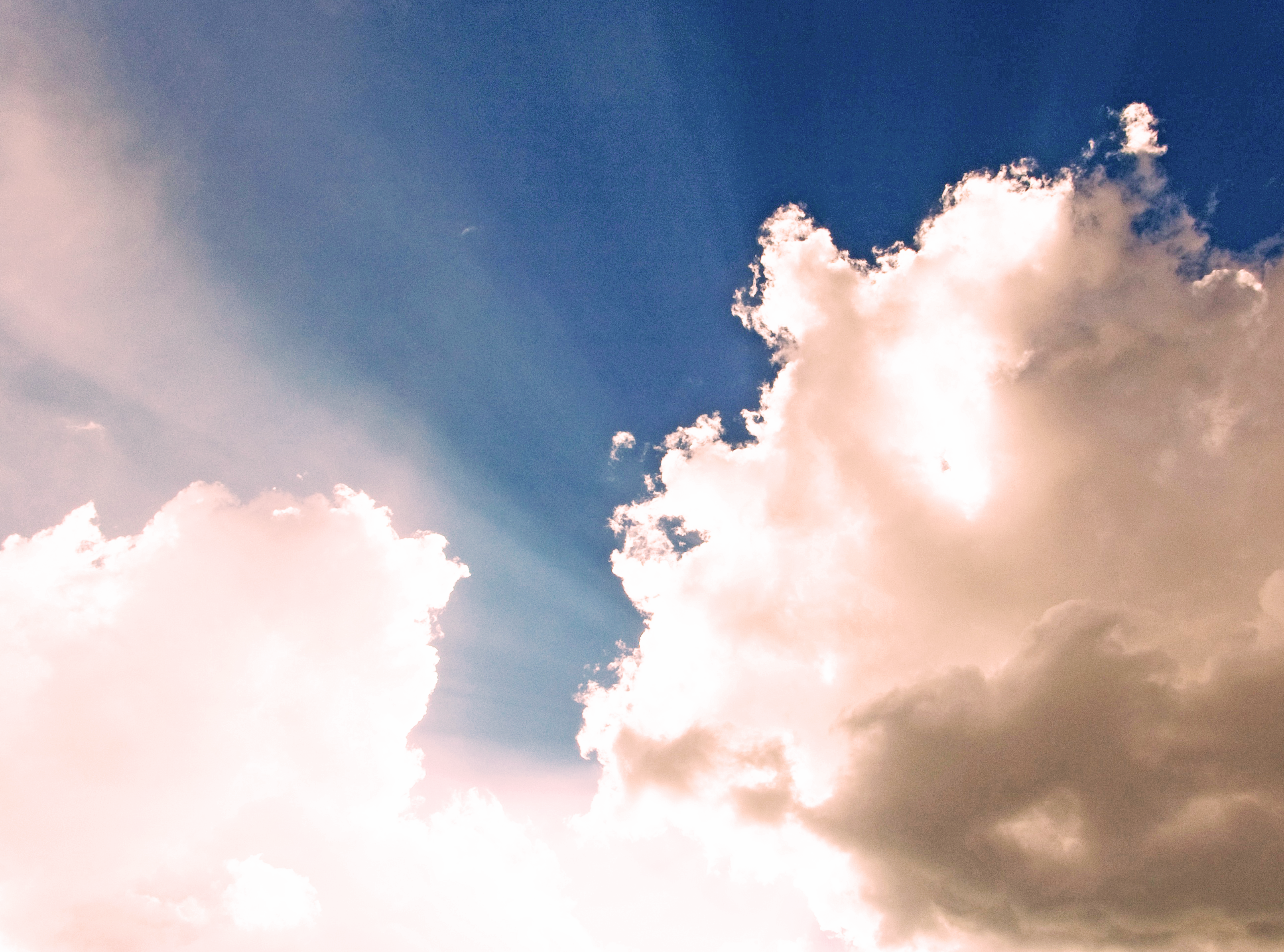 Light breaking through clouds in a pink sky